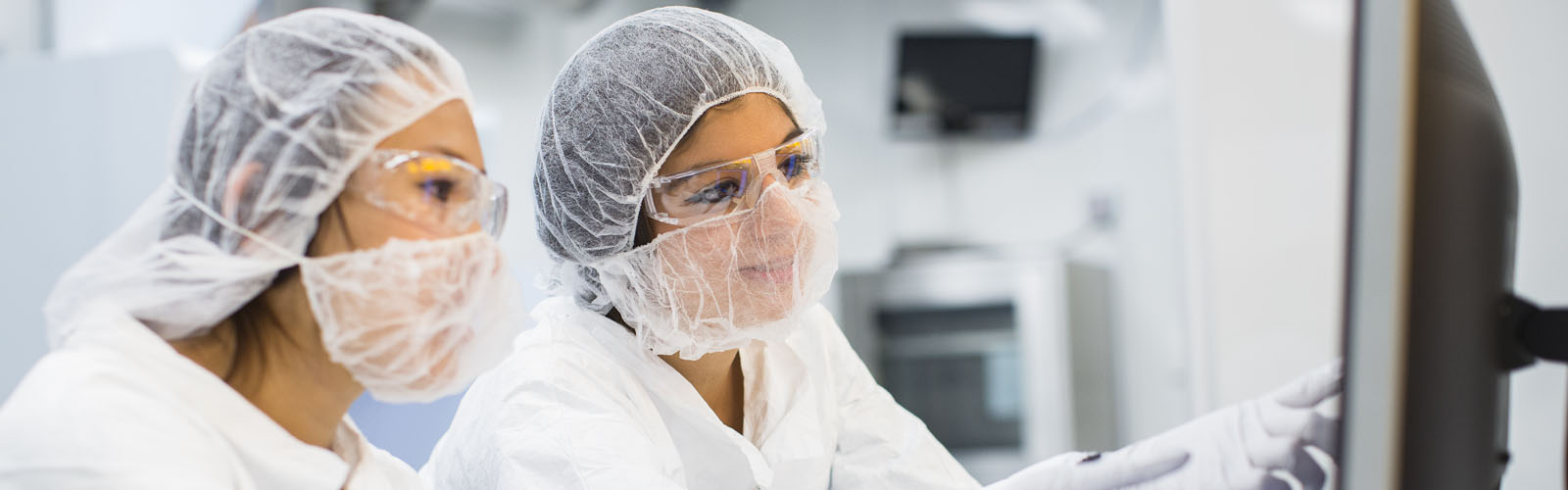 Female students in protective gear research in lab