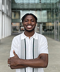 Male in white shirt standing in front of building